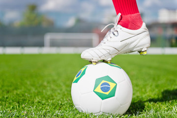 Foot on soccer ball with Brazil's flag
