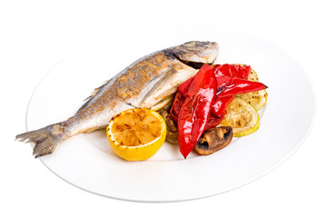 Grilled seabass with vegetables on plate.