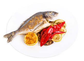 Grilled seabass with vegetables on plate.
