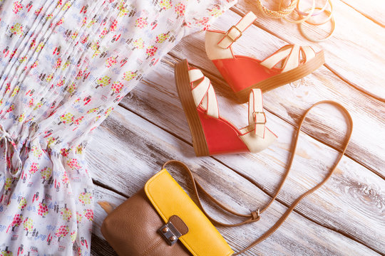 Wedge sandals and bicolor purse. Colorful bracelet set with bag. Woman's summer footwear on display. Clothing and accessories.