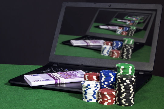 Laptop with money and poker chips