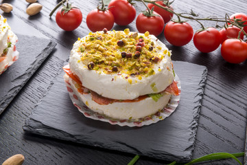 Tortino di formaggio cremoso  e salmone affumicato su piatto di ardesia ambientato 