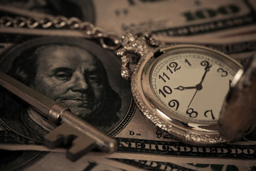 Fototapeta na wymiar Time and money concept image - old silver pocket watch and US cu