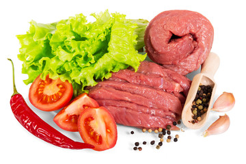 Raw beef with spices, lettuce and tomatoes isolated on white.