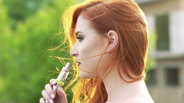 Close up face profile, girl smoking e-cigarette with fume. Slow motion