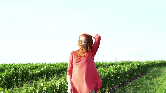 Cute girl posing in the green wheat field. Slowly