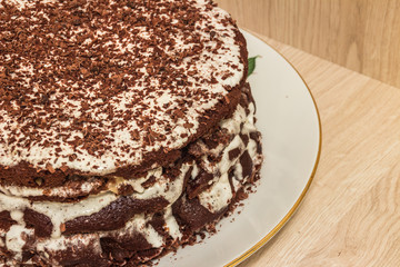 Сhocolate cake is soaked in sour cream and decorated with chocolate shavings