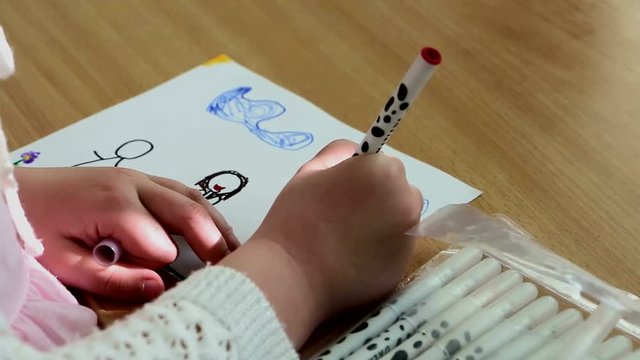 Ребенок рисует фломастерами. Девочка погружена в свои фантазии. Она с увлечением и удовольствием творит, придумывает, 