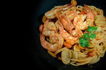 Prawn tomato spagetti on black background