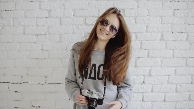 Portrait stylish pretty girl hipster in sunglasses with retro camera having fun