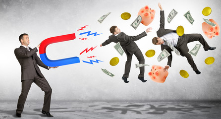 Businessman in suit holding big magnet