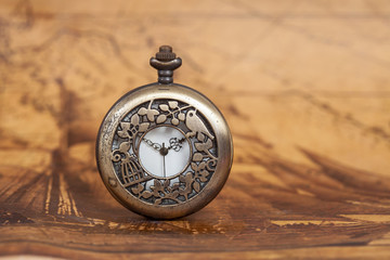 Pocket watch on old map background, vintage style light and tone