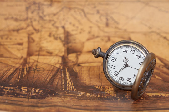 Pocket watch on old map background, vintage style light and tone