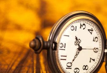 Pocket watch on old map background, vintage style light and tone