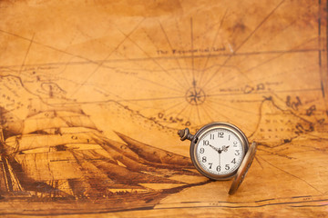 Pocket watch on old map background, vintage style light and tone