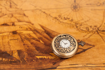 Pocket watch on old map background, vintage style light and tone