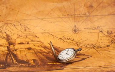 Fototapeta na wymiar Pocket watch on old map background, vintage style light and tone