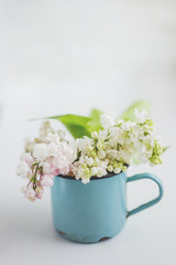 Lilac flowers in old rusty mug. Natural spring background. Place for text.