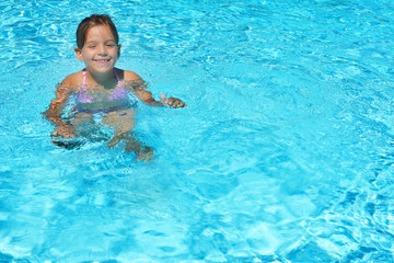 Fototapeta na wymiar Adorable toddler girl enjoying her summer vacation at swimming p
