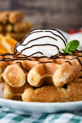 Breakfast. Waffles with ice cream and fruit on a rustic wooden table
