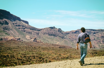 Fototapeta premium Man with his backpack walking on volcanic mountains of Tenerife. Concept for travel o tourism.Vintage style