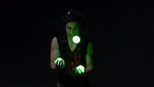 Juggler showing tricks with light balls in the whole dark.Close up.Slow motion