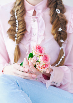 Closeup woman hands with natural manicure holding beautiful delicate branch of pink roses