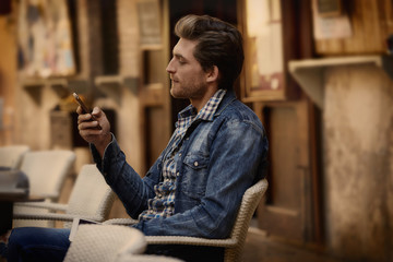 Young man with smartphone in an cafe outdoor