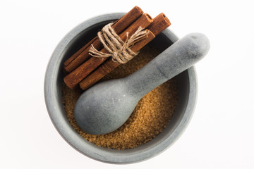 Cinnamon sticks with pure cane brown sugar in mortar