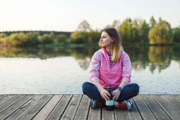 Girl sits near the pond