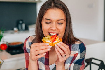 Beautiful young woman eating sweet dessert.