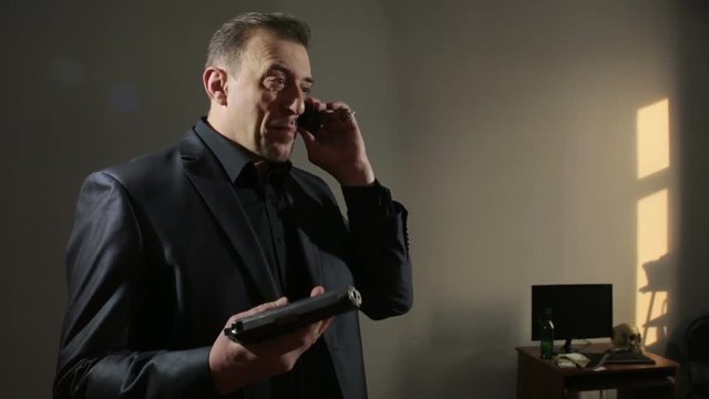 angry businessman waving his gun, said by telephone. threatening interlocutor