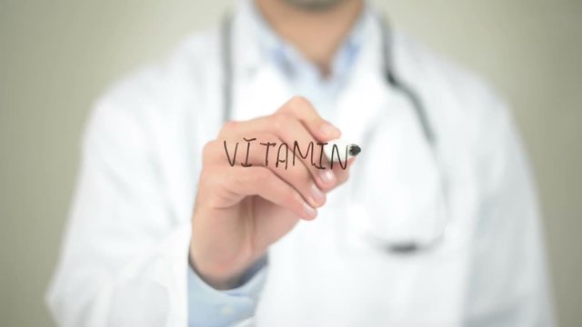 Vitamins, Doctor writing on transparent screen