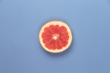 Photo kinds of pop art. Grapefruit on a blue paper texture background in the centr of photo