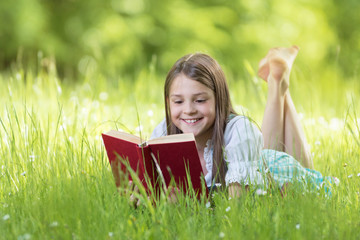 Mädchen beim lesen an einem schönen Sommertag auf der Wiese