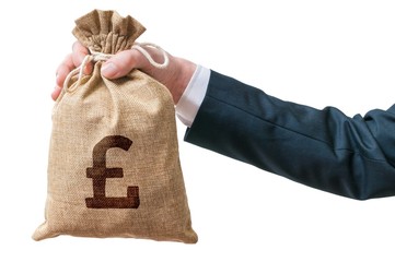 Hand of business man holds bag full of money with British pound sign. Isolated on white background.