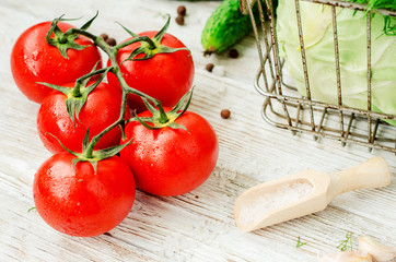 
Fresh juicy ripe summer useful vegetables and greens, red tomatoes , cucumbers , cabbage , lettuce , basil , parsley , dill and salt and spices on a wooden background