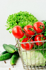 
Fresh juicy ripe summer useful vegetables and greens, red tomatoes , cucumbers , cabbage , lettuce , basil , parsley , dill and salt and spices on a wooden background