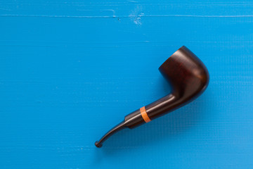 Luxury tobacco pipe on the blue table