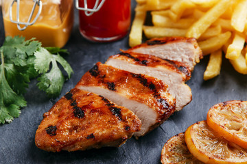Grilled chicken breast with french fries and sauce