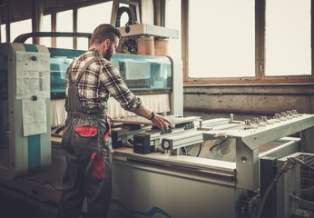 Carpenter doing his job in carpentry workshop.