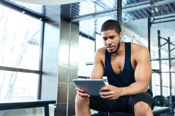 Fitness man with a tablet computer in the gym