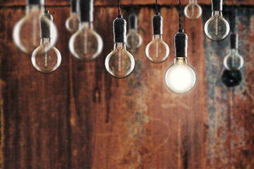 Idea and leadership concept -  bulbs on the grunge background