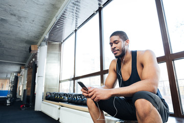 Fitness healthy man using smartphone in the gym