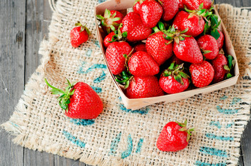 
berries, fresh ripe juicy summer useful red strawberries in a wooden basket on a wooden dark background