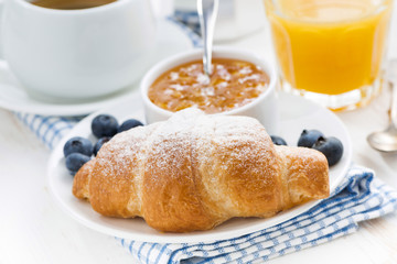 fresh croissant with orange jam, blueberries and coffee