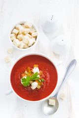 gazpacho with croutons and vegetables in a bowl, vertical