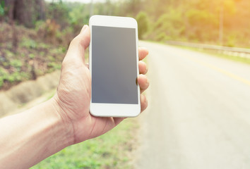 hand holding mobile smartphone on the road