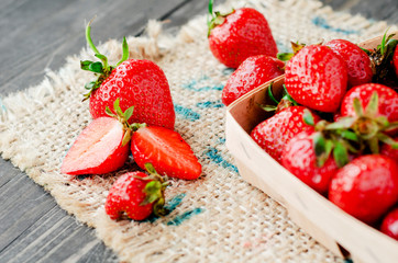 
berries, fresh ripe juicy summer useful red strawberries in a wooden basket on a wooden dark background