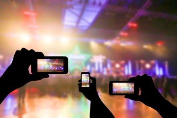 Take photo crowd in front of concert stage blurred